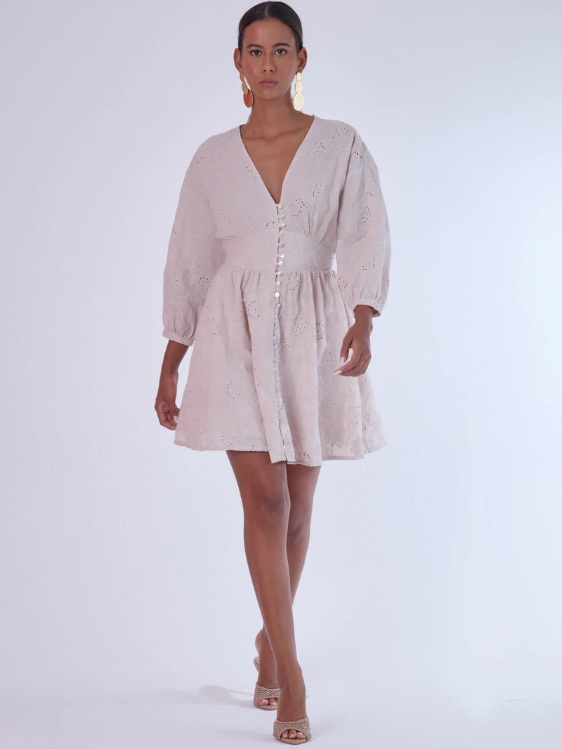 Este vestido de silueta femenina combina un escote en V profundo con una cintura marcada que estiliza la figura. Con mangas 3/4 ligeramente abullonadas y delicados detalles bordados, es una prenda ideal para ocasiones especiales de día o eventos semi formales. Su botonadura frontal añade un toque romántico y clásico que realza su diseño atemporal.