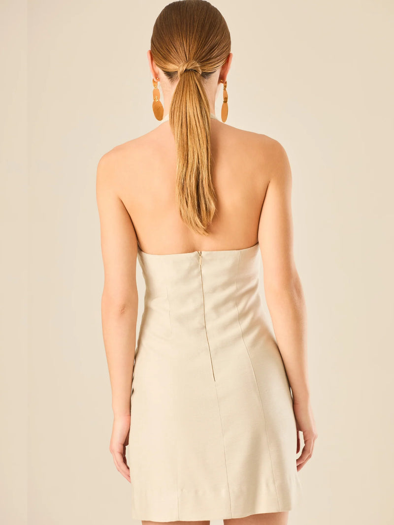 Vestido corto en tono crema de silueta ajustada con escote halter profundo que se adorna con un original detalle de argollas decorativas en el centro del busto, creando un sutil efecto de abertura. Su diseño minimalista con acento sensual lo convierte en una prenda ideal para ocasiones especiales con un toque moderno y sofisticado.

Color: Cemento

Material: 92% Rayon 8% poliester

Características: Incluye hebilla.