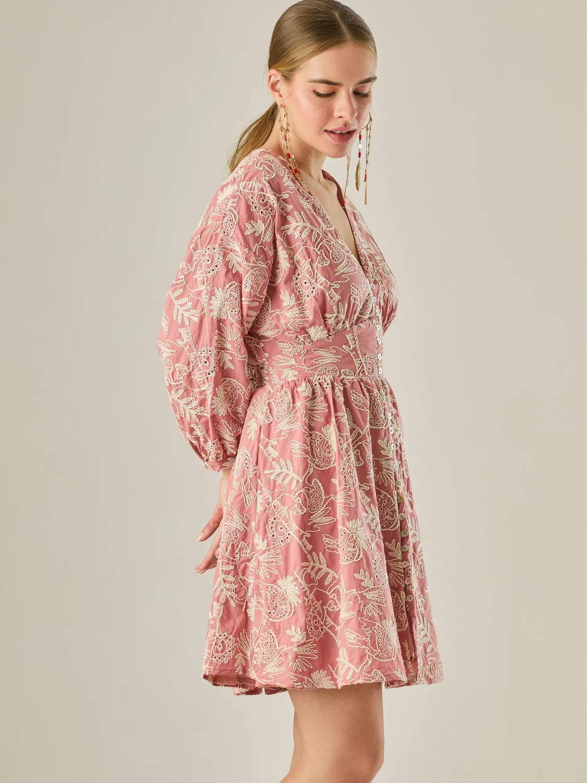 Este vestido de silueta femenina combina un escote en V profundo con una cintura marcada que estiliza la figura. Con mangas 3/4 ligeramente abullonadas y delicados detalles bordados, es una prenda ideal para ocasiones especiales de día o eventos semi formales. Su botonadura frontal añade un toque romántico y clásico que realza su diseño atemporal.

Detalles:

Color: Coral