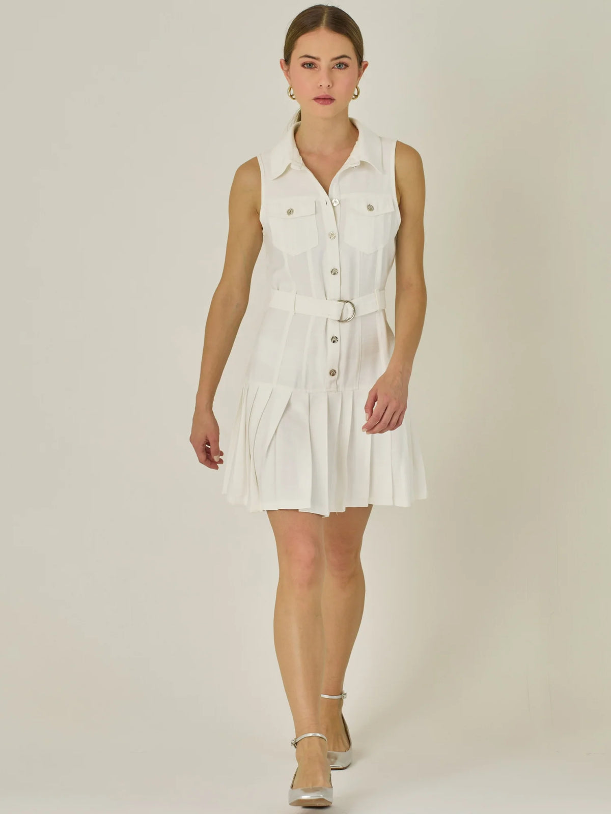 Vestido corto sin mangas con estructura camisera, bolsillos frontales y falda plisada que aporta movimiento y estilo. El cinturón ajustable realza la silueta, logrando un look casual con un toque sofisticado, ideal para días activos con mucho estilo.

Detalles:

Color: Blanco Perla

Material: 93% Rayón 7% Poliéster

Características: Incluye cinturón a tono .