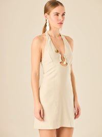 Vestido corto en tono crema de silueta ajustada con escote halter profundo que se adorna con un original detalle de argollas decorativas en el centro del busto, creando un sutil efecto de abertura. Su diseño minimalista con acento sensual lo convierte en una prenda ideal para ocasiones especiales con un toque moderno y sofisticado.

Color: Cemento

Material: 92% Rayon 8% poliester

Características: Incluye hebilla.