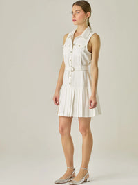 Vestido corto sin mangas con estructura camisera, bolsillos frontales y falda plisada que aporta movimiento y estilo. El cinturón ajustable realza la silueta, logrando un look casual con un toque sofisticado, ideal para días activos con mucho estilo.

Detalles:

Color: Blanco Perla

Material: 93% Rayón 7% Poliéster

Características: Incluye cinturón a tono .