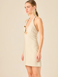 Vestido corto en tono crema de silueta ajustada con escote halter profundo que se adorna con un original detalle de argollas decorativas en el centro del busto, creando un sutil efecto de abertura. Su diseño minimalista con acento sensual lo convierte en una prenda ideal para ocasiones especiales con un toque moderno y sofisticado.

Color: Cemento

Material: 92% Rayon 8% poliester

Características: Incluye hebilla.