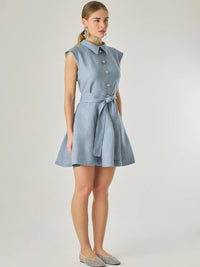 Vestido corto sin mangas con botones frontales y cuello camisero, complementado con un lazo que define la cintura. Su diseño sencillo y femenino lo convierte en una opción ideal para un look casual con un aire sofisticado y fresco.

Color: Indigo

Material: Lino

Características: Incluye cinturón a tono.