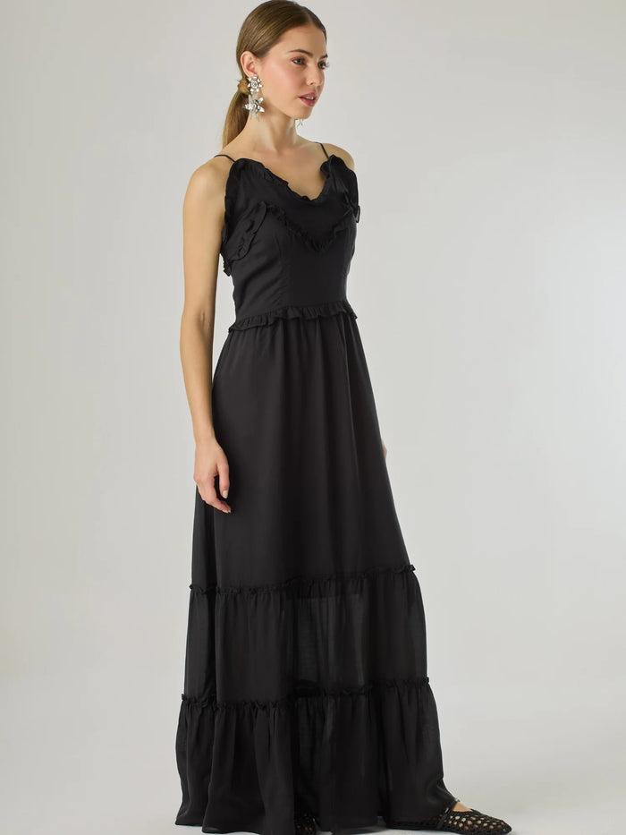 Vestido largo con volantes delicados y silueta fluida, ideal para un look femenino y relajado. Su diseño cómodo y versátil combina elegancia natural con un toque romántico, perfecto para los días cálidos.

Detalles:

Color: Negro

Material: 100% Lyocel