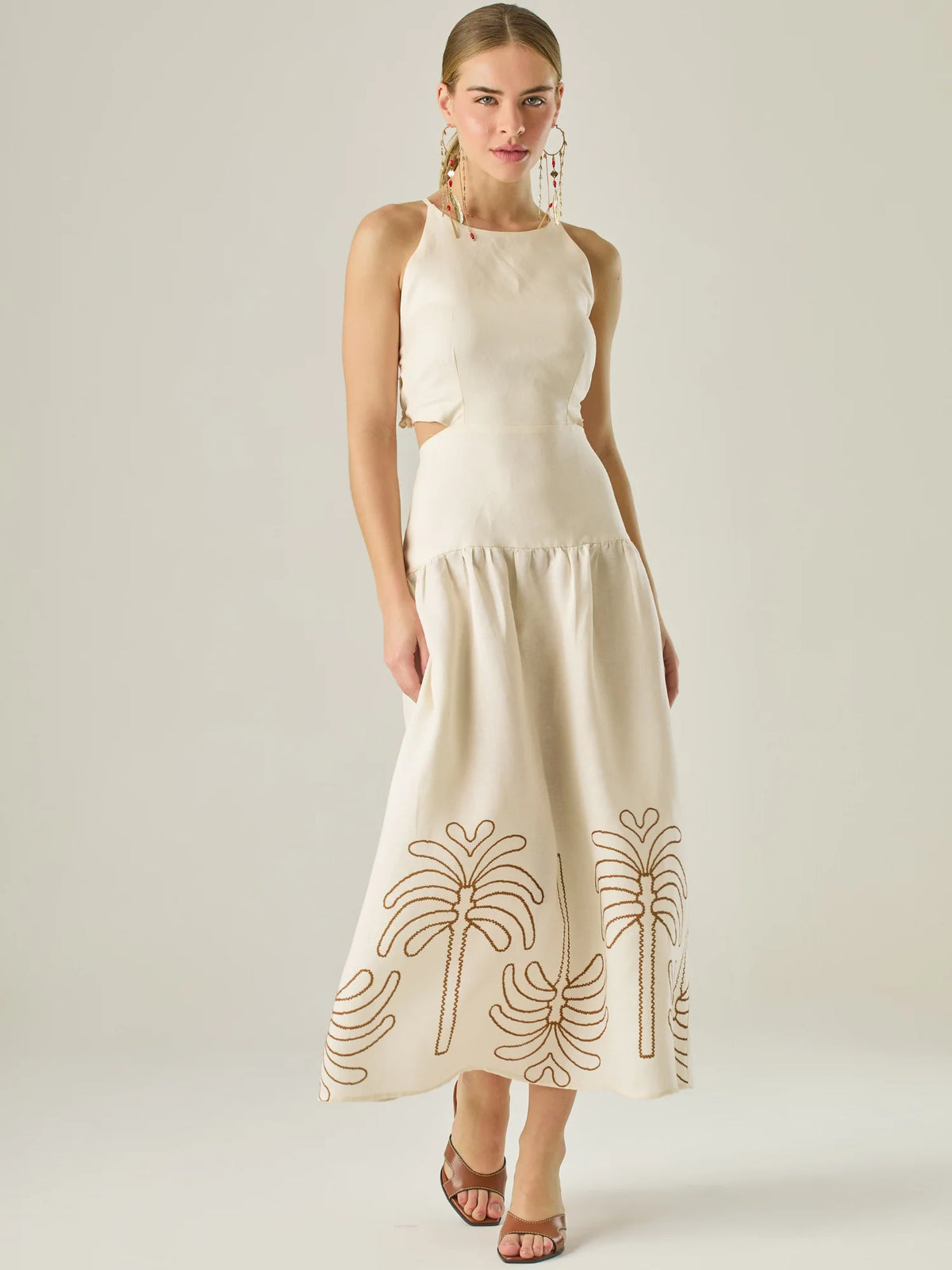 Vestido largo sin mangas con escote recto, aberturas laterales y detalle bordado en el bajo con motivos de inspiración natural. Su diseño limpio y femenino lo convierte en una opción ideal para un look sofisticado con un aire fresco y artesanal.

Detalles:

Color: Sand