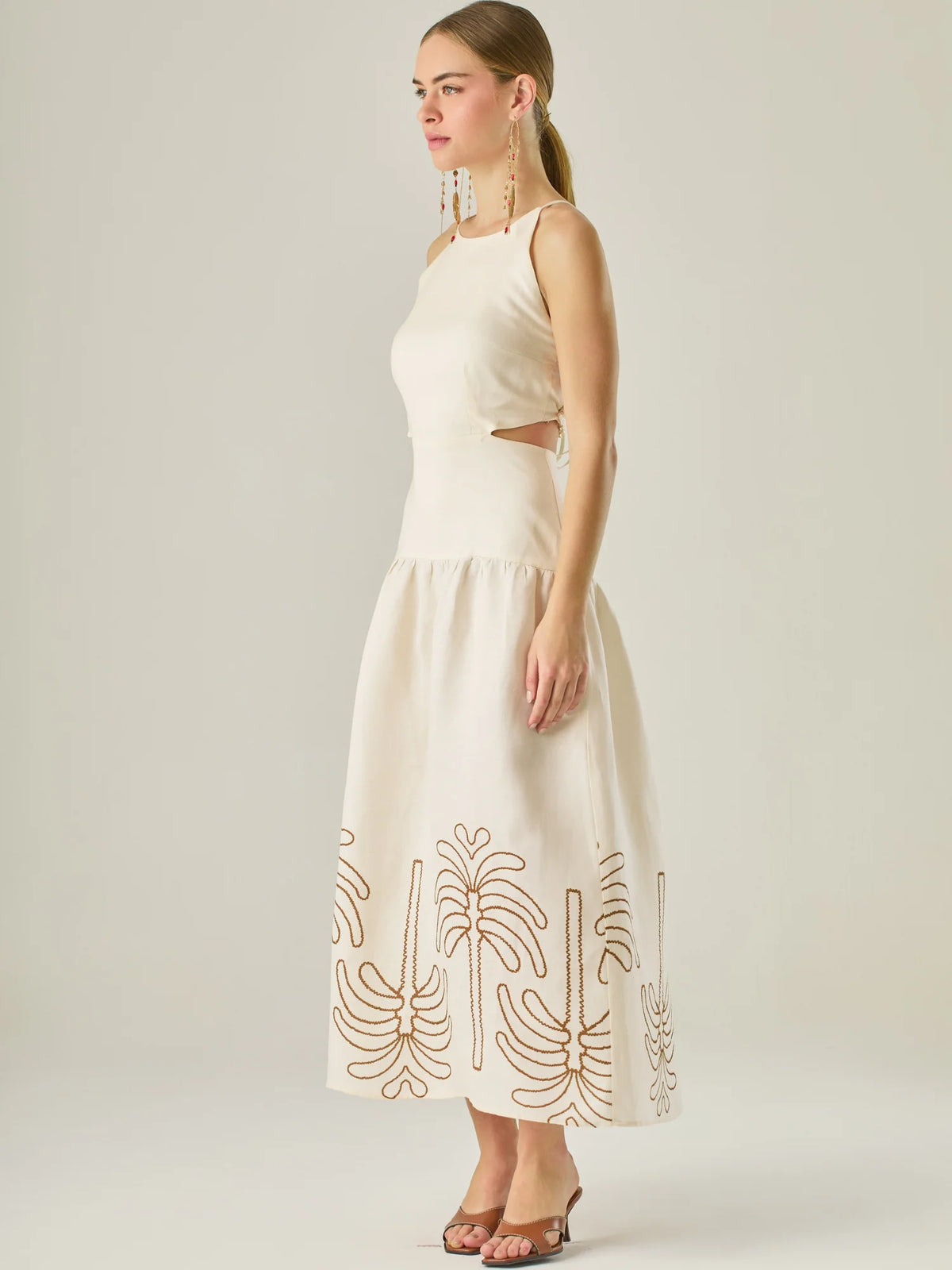 Vestido largo sin mangas con escote recto, aberturas laterales y detalle bordado en el bajo con motivos de inspiración natural. Su diseño limpio y femenino lo convierte en una opción ideal para un look sofisticado con un aire fresco y artesanal.

Detalles:

Color: Sand