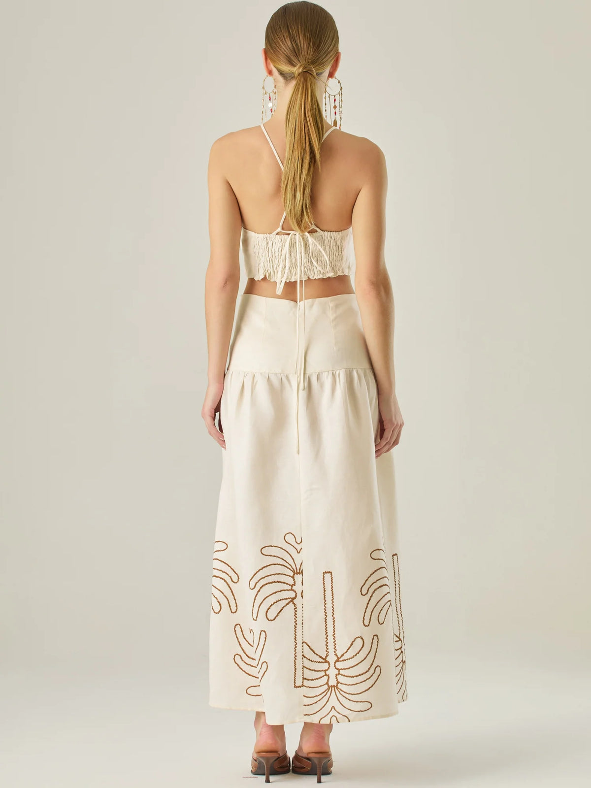 Vestido largo sin mangas con escote recto, aberturas laterales y detalle bordado en el bajo con motivos de inspiración natural. Su diseño limpio y femenino lo convierte en una opción ideal para un look sofisticado con un aire fresco y artesanal.

Detalles:

Color: Sand
