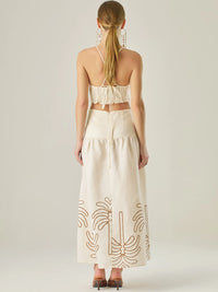 Vestido largo sin mangas con escote recto, aberturas laterales y detalle bordado en el bajo con motivos de inspiración natural. Su diseño limpio y femenino lo convierte en una opción ideal para un look sofisticado con un aire fresco y artesanal.

Detalles:

Color: Sand