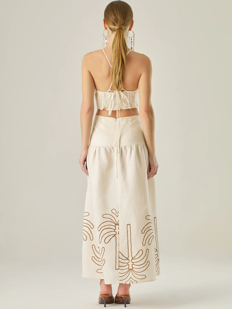 Vestido largo sin mangas con escote recto, aberturas laterales y detalle bordado en el bajo con motivos de inspiración natural. Su diseño limpio y femenino lo convierte en una opción ideal para un look sofisticado con un aire fresco y artesanal.

Detalles:

Color: Sand