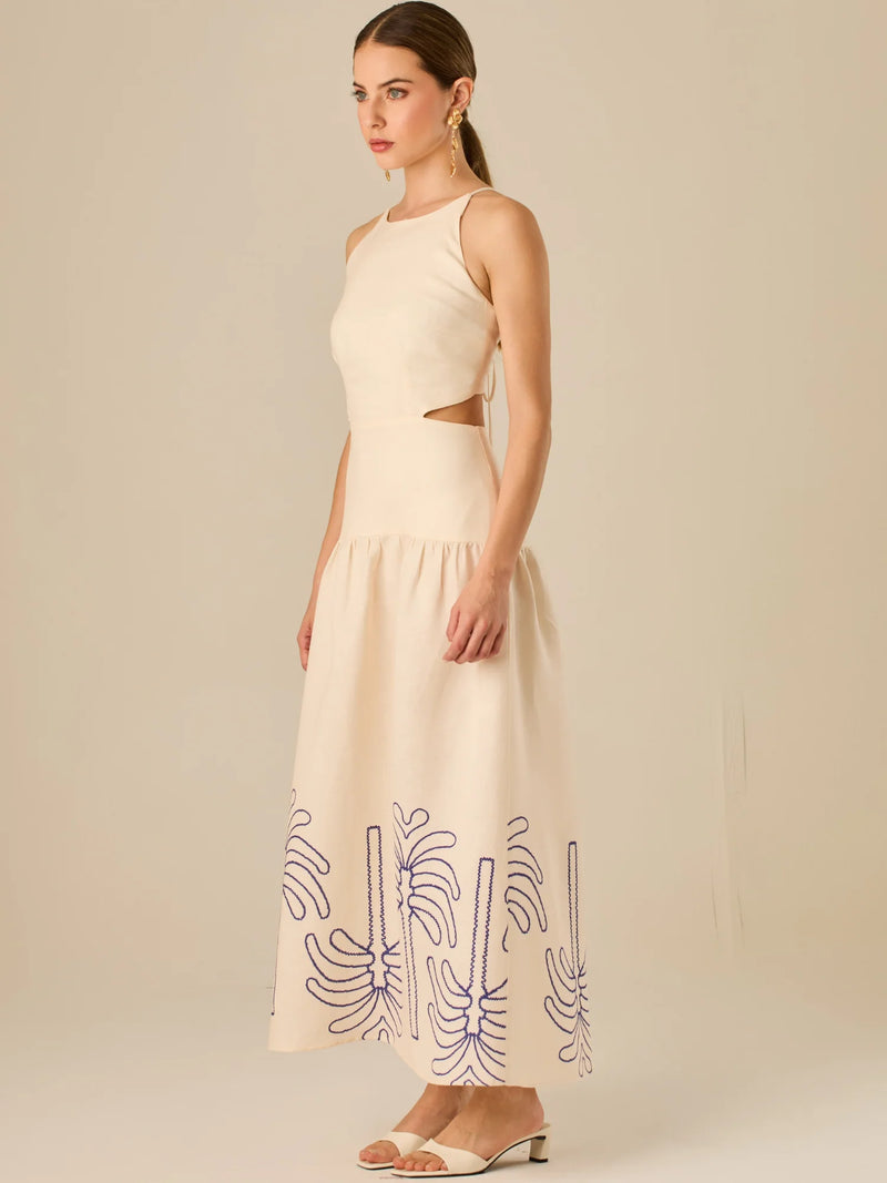 Vestido largo sin mangas con escote recto, aberturas laterales y detalle bordado en el bajo con motivos de inspiración natural. Su diseño limpio y femenino lo convierte en una opción ideal para un look sofisticado con un aire fresco y artesanal.

Detalles:

Color: Sand

Materia: 52% Lino 48% Rayon