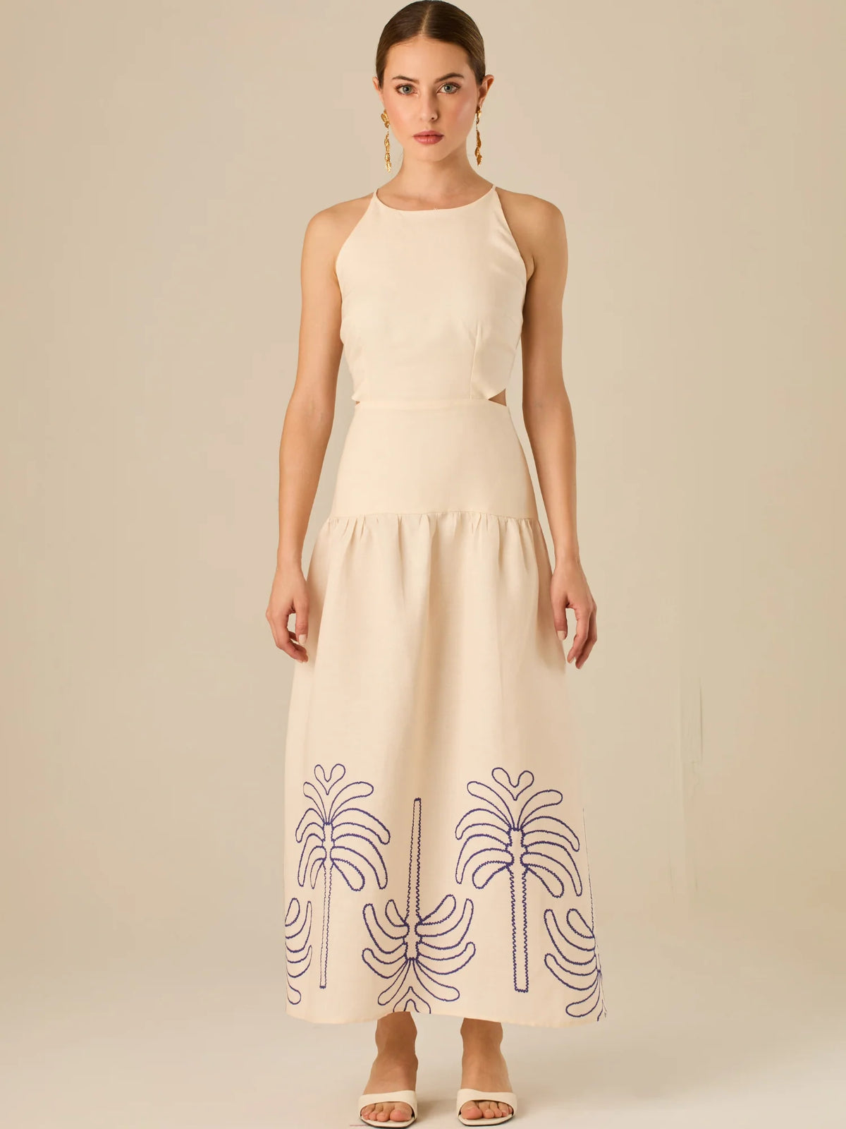 Vestido largo sin mangas con escote recto, aberturas laterales y detalle bordado en el bajo con motivos de inspiración natural. Su diseño limpio y femenino lo convierte en una opción ideal para un look sofisticado con un aire fresco y artesanal.

Detalles:

Color: Sand

Materia: 52% Lino 48% Rayon