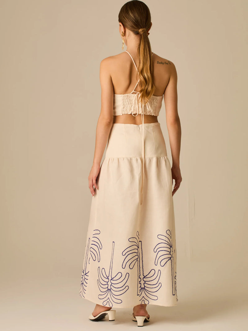 Vestido largo sin mangas con escote recto, aberturas laterales y detalle bordado en el bajo con motivos de inspiración natural. Su diseño limpio y femenino lo convierte en una opción ideal para un look sofisticado con un aire fresco y artesanal.

Detalles:

Color: Sand

Materia: 52% Lino 48% Rayon