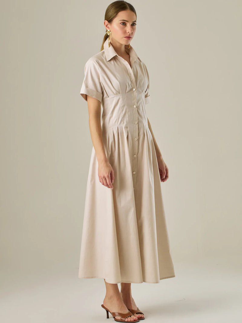 Vestido camisero midi con mangas cortas y falda amplia, ideal para un look elegante y relajado. Su diseño con pinzas en el busto realza la figura con sutileza, mientras que los botones al frente aportan un toque clásico y versátil.

Detalles:

Color: Sand

Material: 97% Algodón 3% Spandex