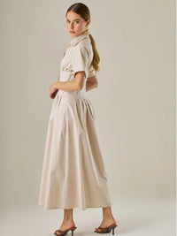 Vestido camisero midi con mangas cortas y falda amplia, ideal para un look elegante y relajado. Su diseño con pinzas en el busto realza la figura con sutileza, mientras que los botones al frente aportan un toque clásico y versátil.

Detalles:

Color: Sand

Material: 97% Algodón 3% Spandex