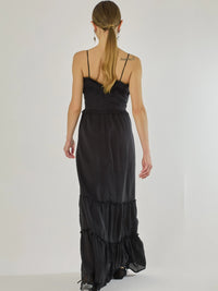 Vestido largo con volantes delicados y silueta fluida, ideal para un look femenino y relajado. Su diseño cómodo y versátil combina elegancia natural con un toque romántico, perfecto para los días cálidos.

Detalles:

Color: Negro

Material: 100% Lyocel