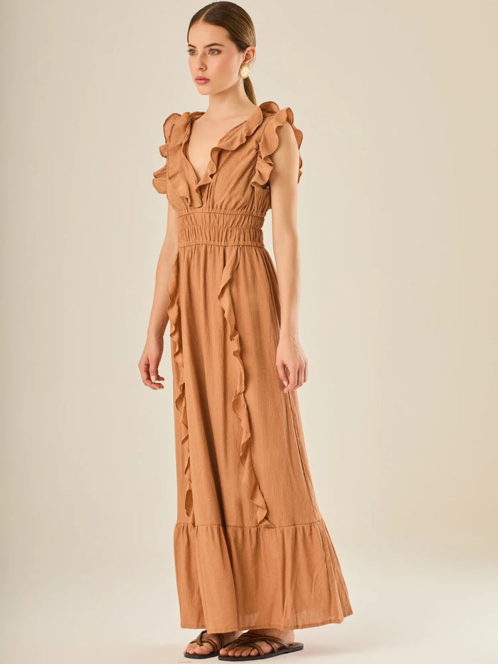 Vestido largo sin mangas con escote en "V" profundo y un diseño con volantes que recorren tanto los tirantes como la parte frontal del busto y la falda. La cintura está fruncida con elástico para dar definición y comodidad, mientras que la falda fluye suavemente con un detalle de volante en el dobladillo, aportando movimiento y un aire femenino al conjunto.

Detalles:

Color: Cafe