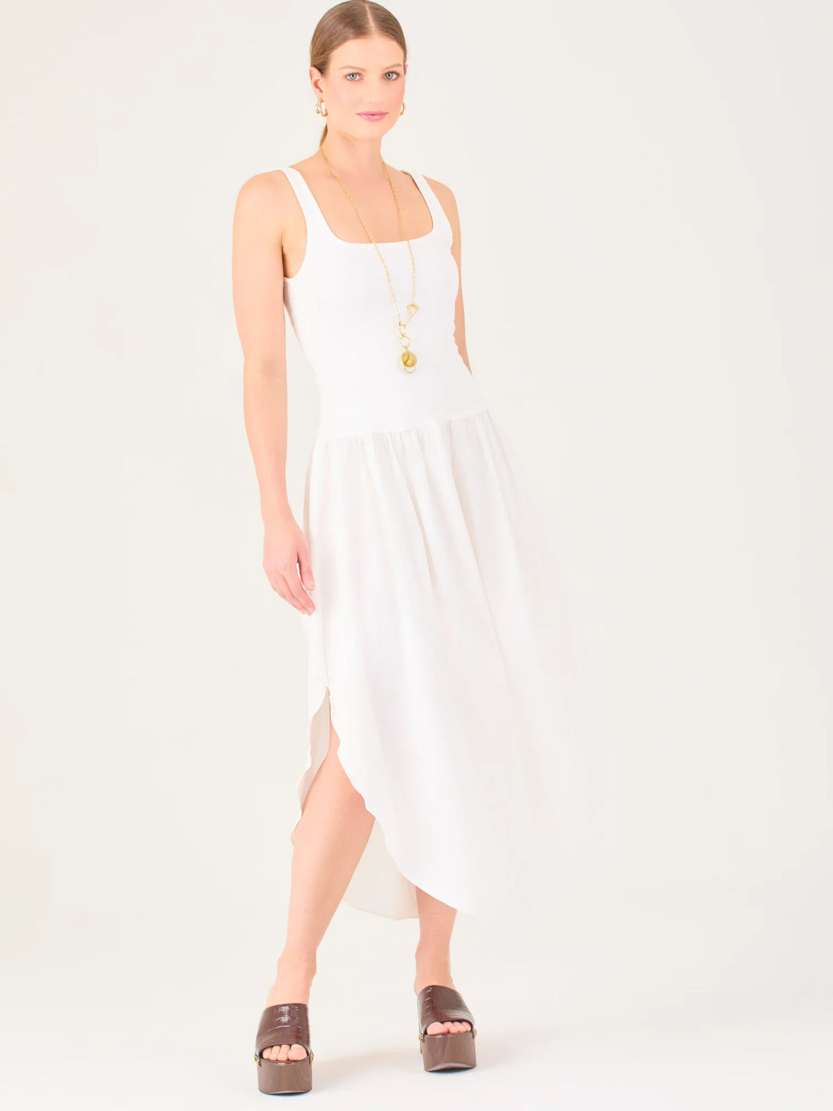 Vestido midi de líneas limpias con tirantes anchos y escote recto. Cuerpo suavemente entallado que cae a una cintura baja fruncida y una falda amplia con bajo redondeado asimétrico tipo pétalo. Una pieza fresca y sofisticada para elevar looks de día o de tarde

Detalles:

Color: Blanco

Material: 95% Poliéster 5% Elastómero 